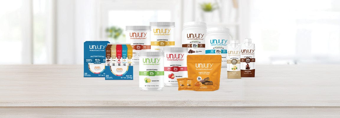 Assorted Unjury product packages on a white surface with a blurred background